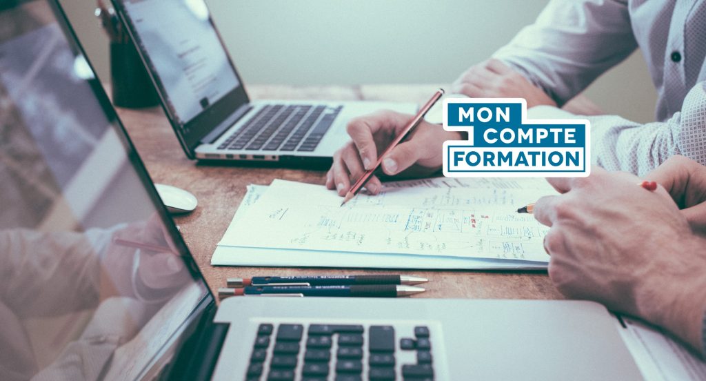 compte-personnel-de-formation-cest-quoi-1024x552 – merci e-commerce – merci e-commerce People working at a desk with laptops and papers; a blue 'MON COMPTE FORMATION' logo in the foreground.